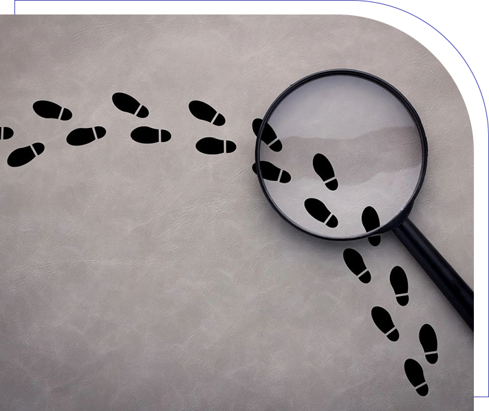 A magnifying glass and footprints on paper